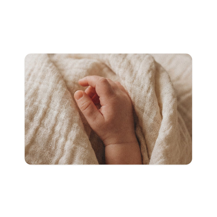 Pet Food Mat - Tender Newborn Hand in Soft Muslin Blanket