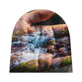 Gorro de bebê em dupla exposição rio e mão surreal